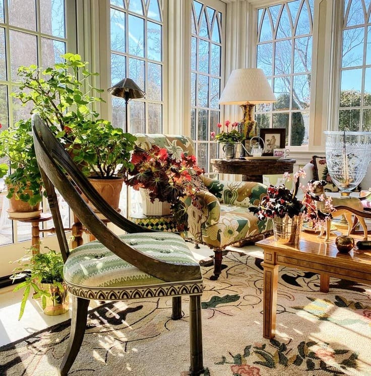 Eclectic sunroom with large arched windows, patterned furniture, and indoor plants