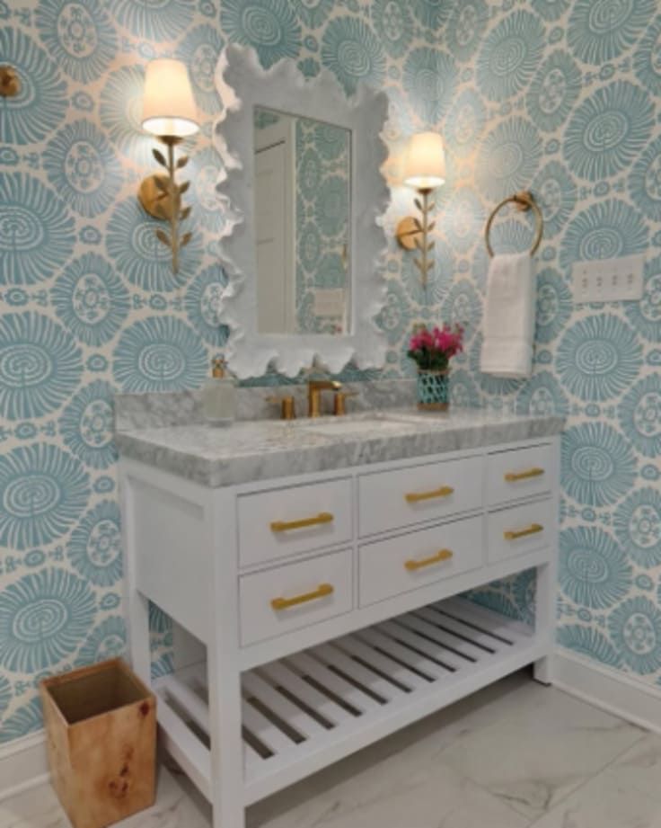 white vanity with gold hardware and blue wallpaper