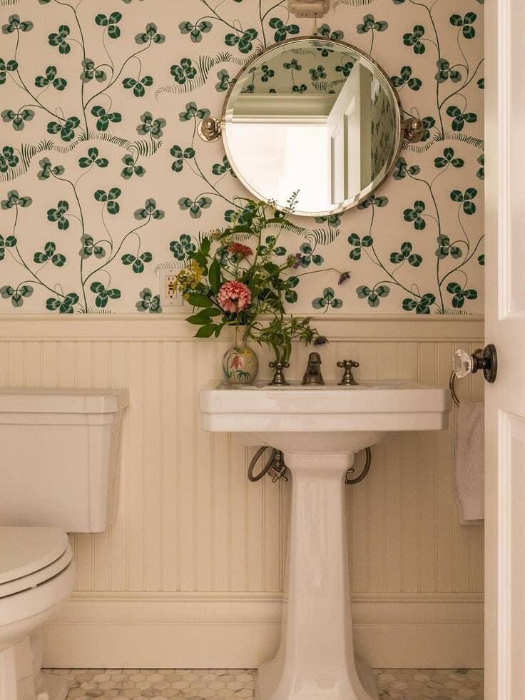 Green floral bathroom wallpaper with white beadboard and pedestal sink