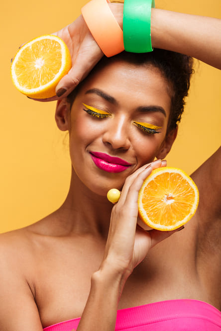 how to get dopamine naturally, women holding two sliced oranges smiling