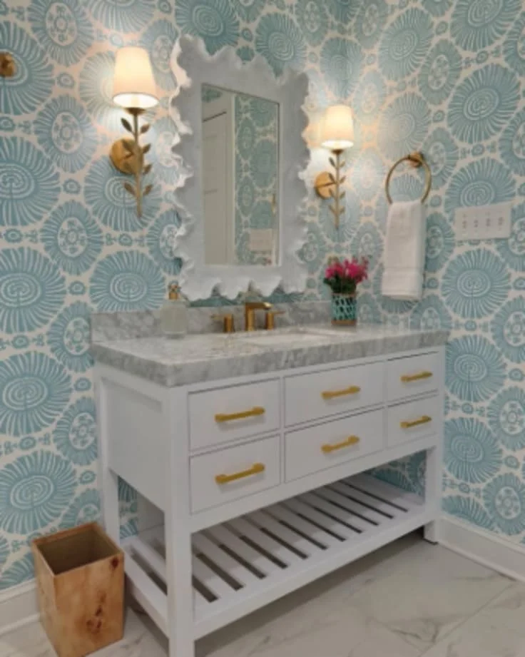 white vanity with gold hardware and blue wallpaper