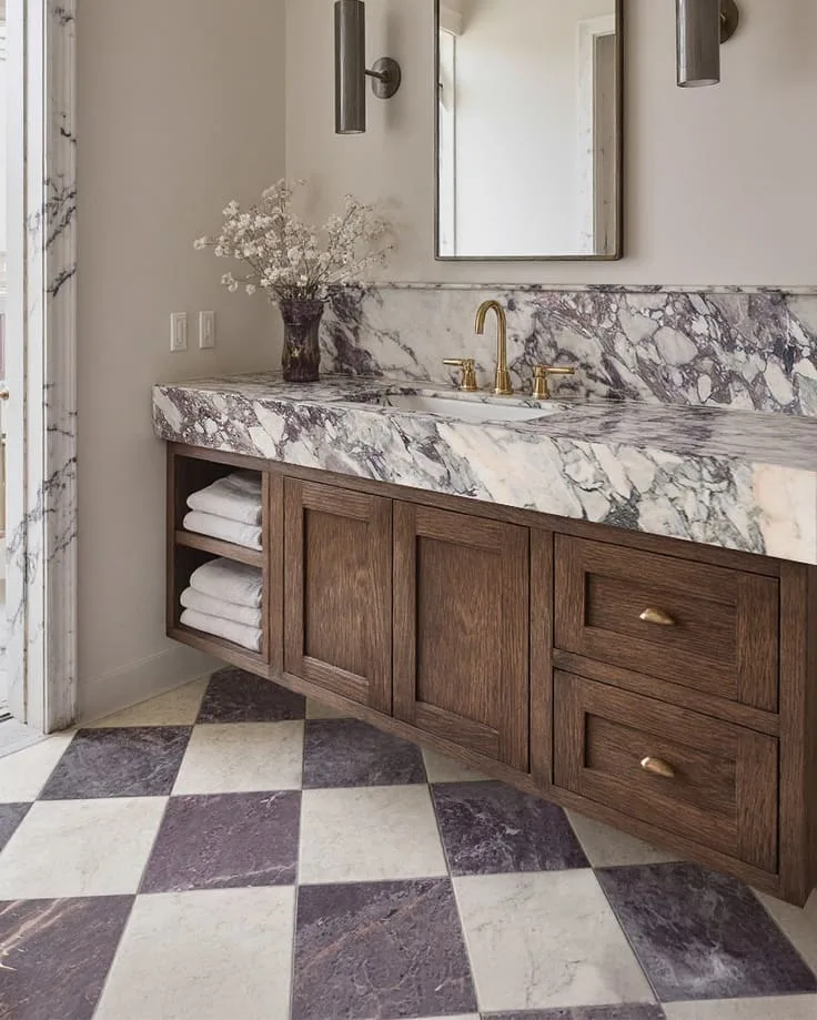 marble vanity with checkered floor and wood drawers