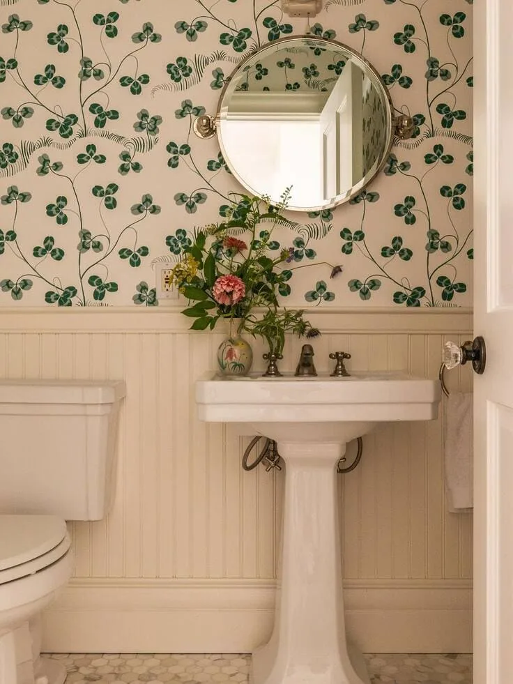 Green floral bathroom wallpaper with white beadboard and pedestal sink