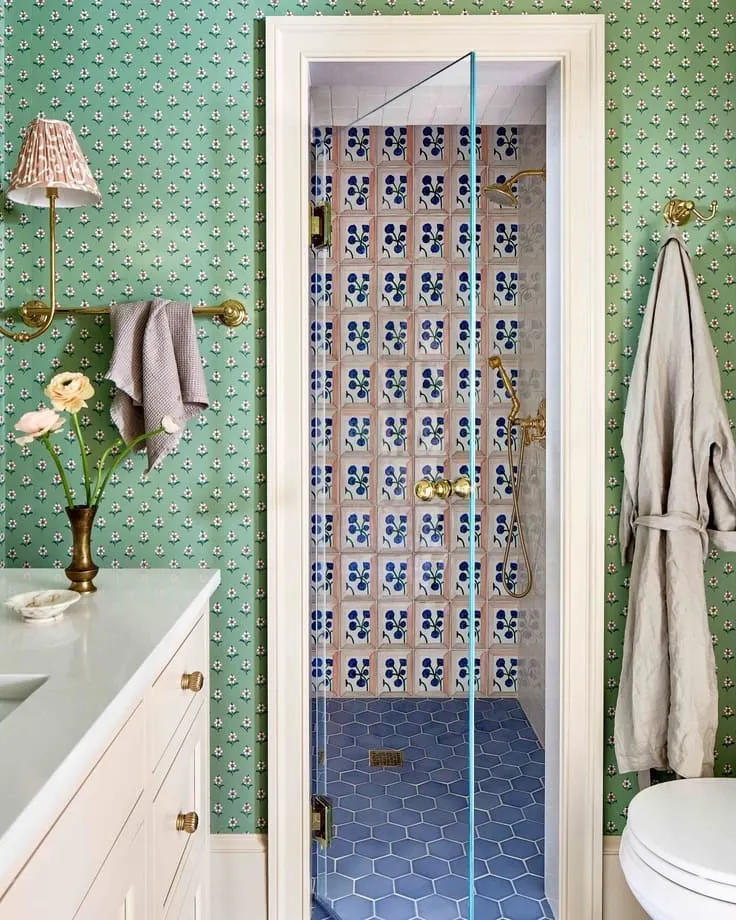 Green patterned bathroom wallpaper with blue hexagon shower floor and floral tiles