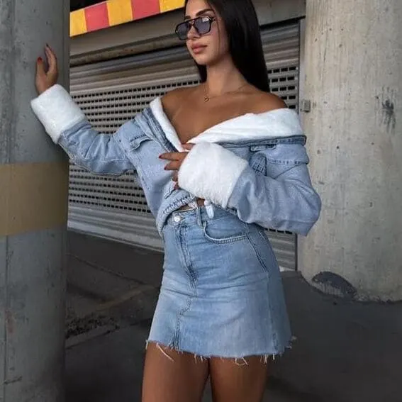 Woman wearing faux fur-lined denim jacket with mini skirt made of denim.
